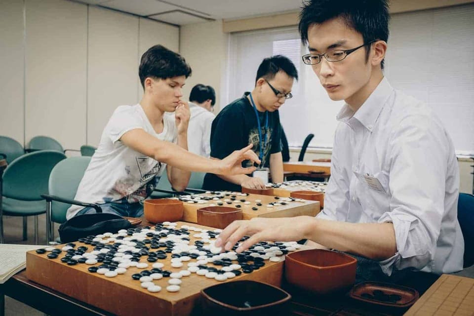 Students playing and studying Go together during a classroom training session