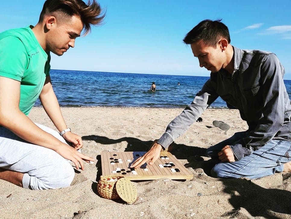 Two players enjoying a game of Go on the beach by Lake Issyk-Kul during the Go festival.