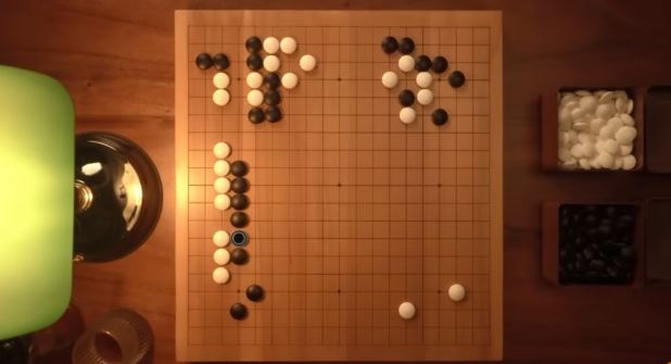 Top-down view of a Go board with a developing position, including vertical stone formations on the left side and corner shapes at the top.