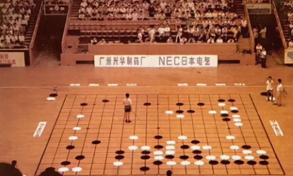 Large-scale Go exhibition game played on a giant board in a stadium setting