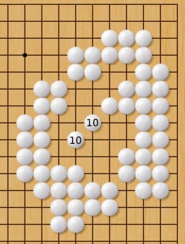 Go board diagram dominated by white stones forming a large enclosure, with two points labeled “10” inside an empty central area.