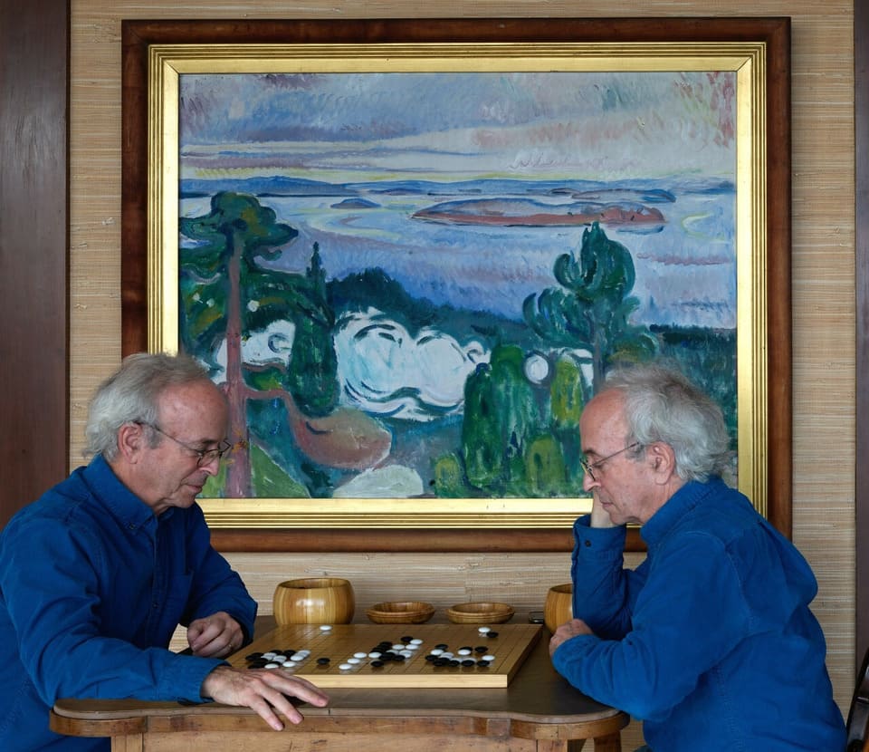 Photo montage showing Phil Straus seated on both sides of a Go board, playing against himself.