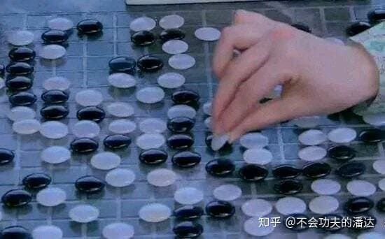 Close-up of a Go board from Swords of Legends showing unusual stone placement and a hand reaching toward the position.