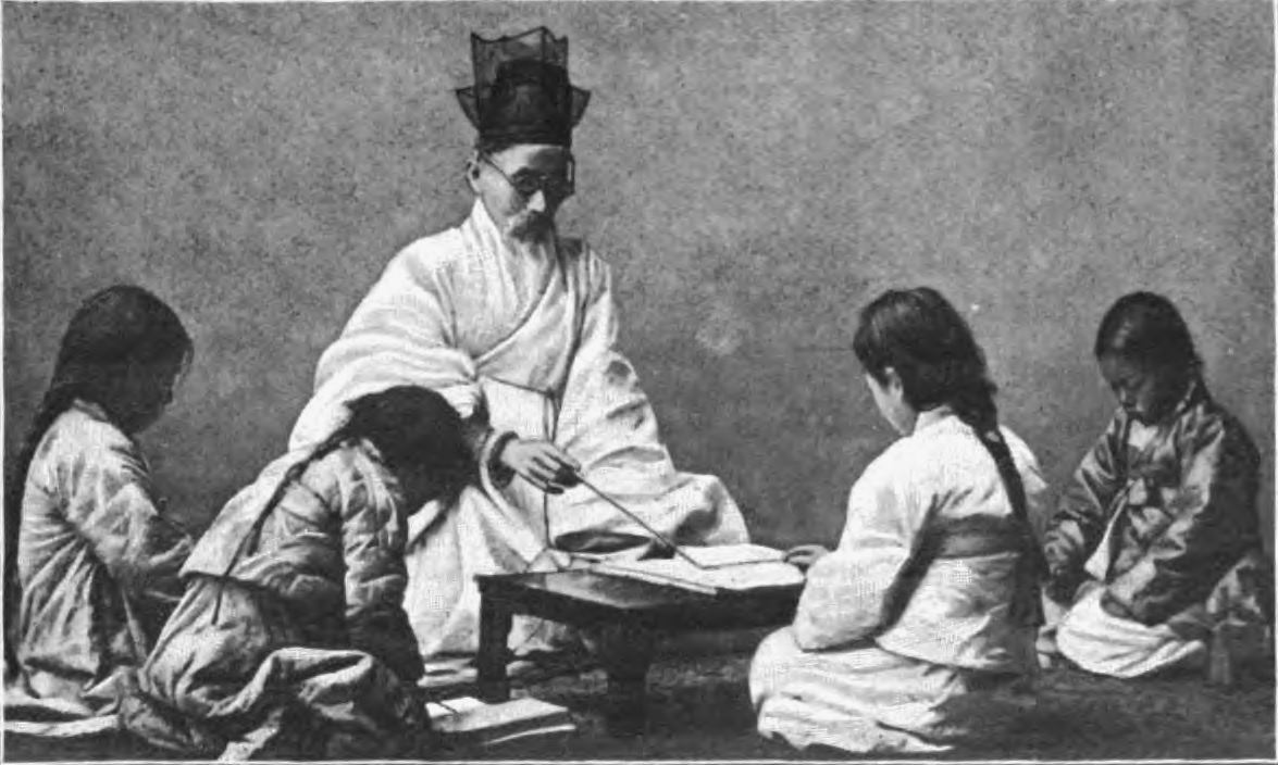 Historical photograph depicting a traditional Go lesson with a master teaching children the game of Go
