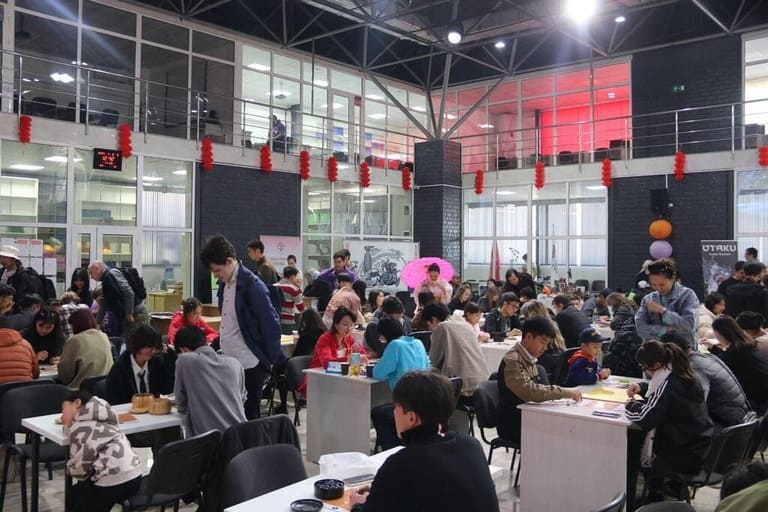 A large hall filled with Go players of different ages competing at a major Kyrgyzstan Go event.