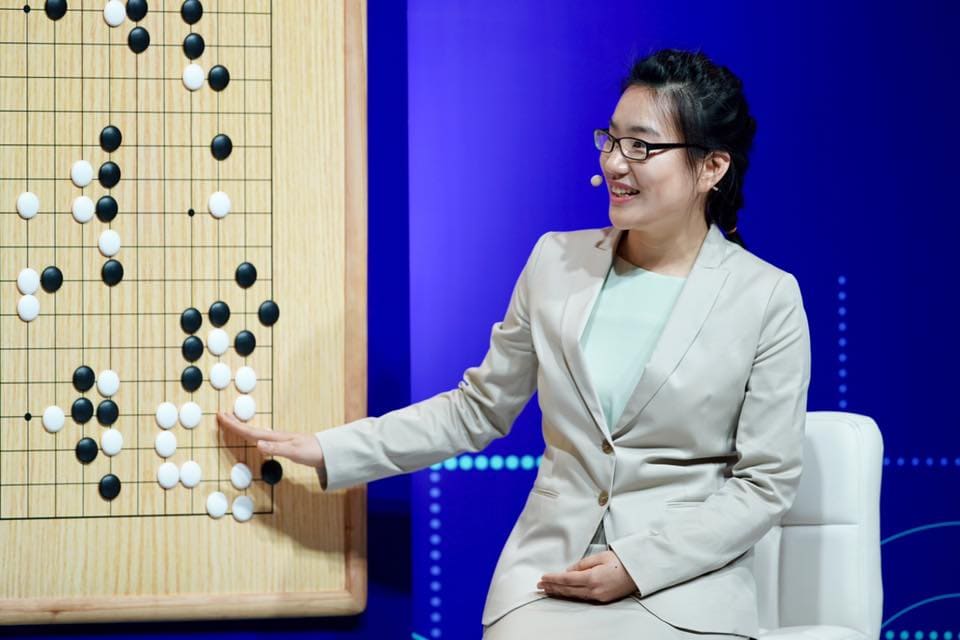 Hajin Lee analyzing a professional Go game on a large board during a live commentary session in Wuzhen