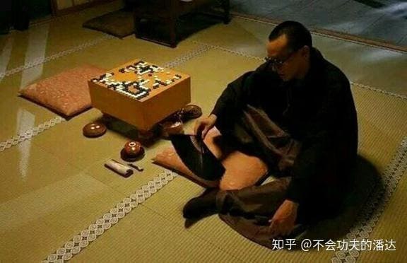A still from The Go Master showing a man in traditional clothing seated beside a Go board with stones in play.