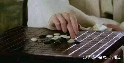 Close-up from Swords of Legends showing a hand holding a Go stone incorrectly above a dark board.