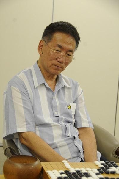 Rin Kaiho seated at a Go board with black and white stones at the Nihon Ki-in in 2015.