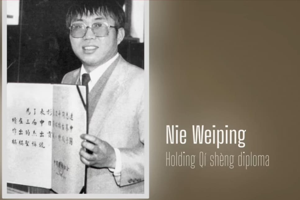 Archival photo of Nie Weiping holding his Qi Sheng honorary diploma