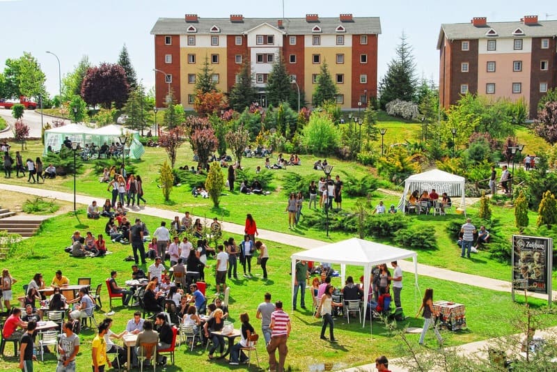 People gathering on a green lawn between university buildings at Hacettepe University’s Beytepe Campus in Ankara