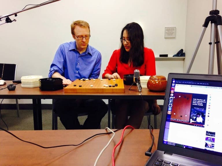 Hajin Lee and a fellow player reviewing a Go position during a teaching session at an international Go congress