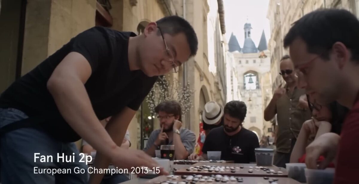 Fan Hui playing Go against multiple opponents during a public event
