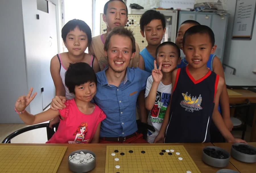 Go instructor posing with children during a beginner Go lesson
