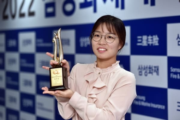 Choi Jeong proudly holding her Go tournament award trophy