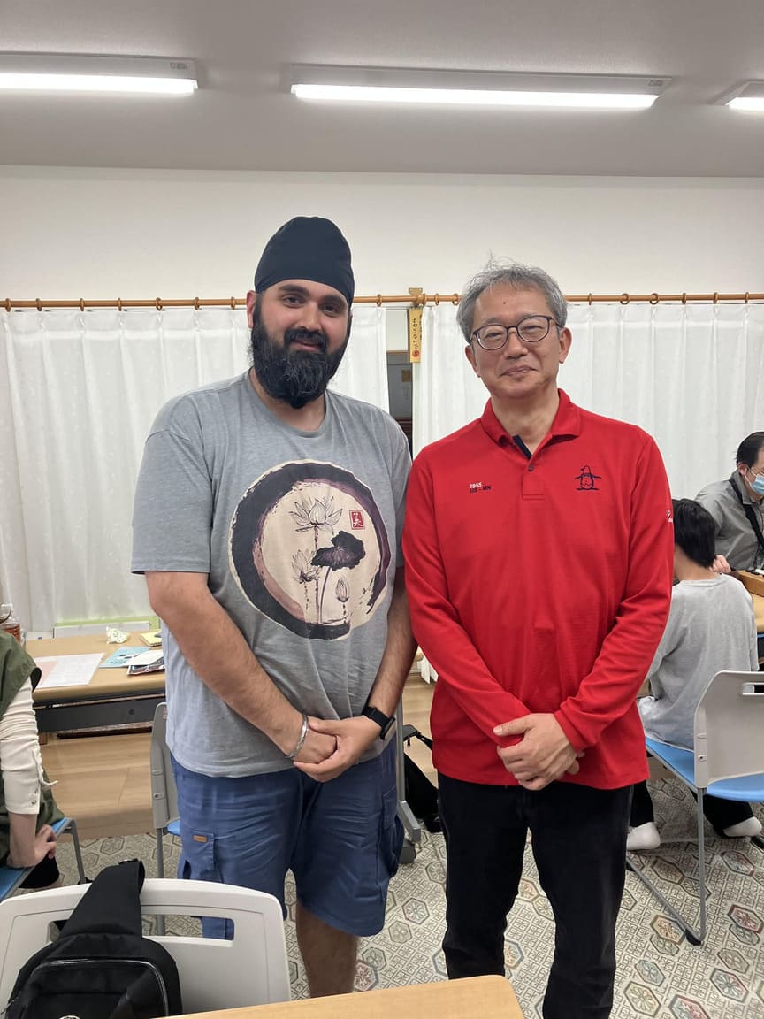 Two men posing together in a classroom during Osaka Go Camp
