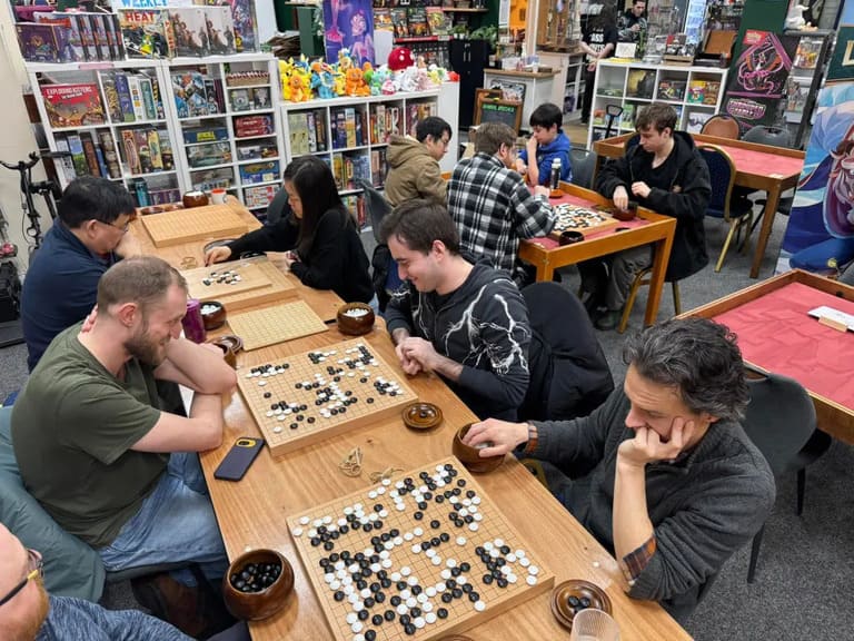 Several people playing Go together in a casual local club setting.