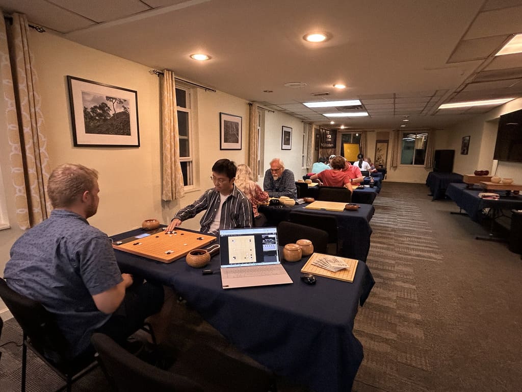 Players at Go boards in the National Go Center in Washington, D.C., with a laptop recording the nearest game.