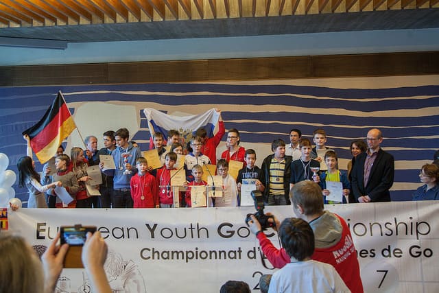 Young Go players standing on stage during a European Youth Go Championship award ceremony.