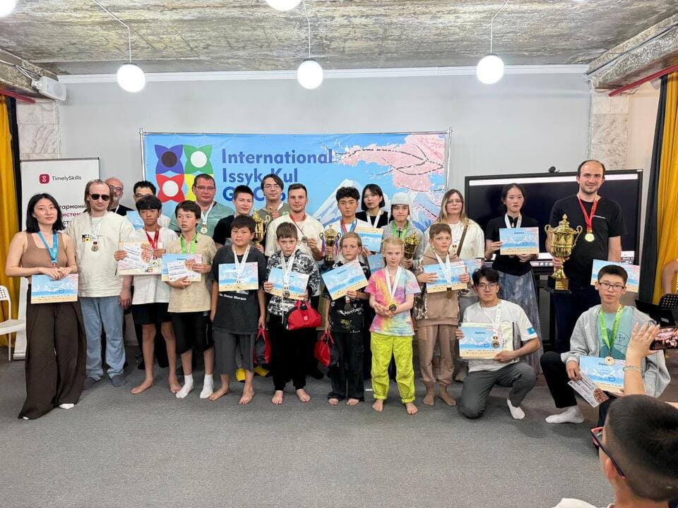 Group photo of Issyk-Kul Cup participants and winners holding certificates, medals, and trophies.