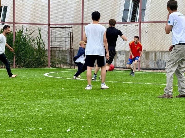 Participants of a Go event in Kyrgyzstan enjoying a casual soccer game outdoors.