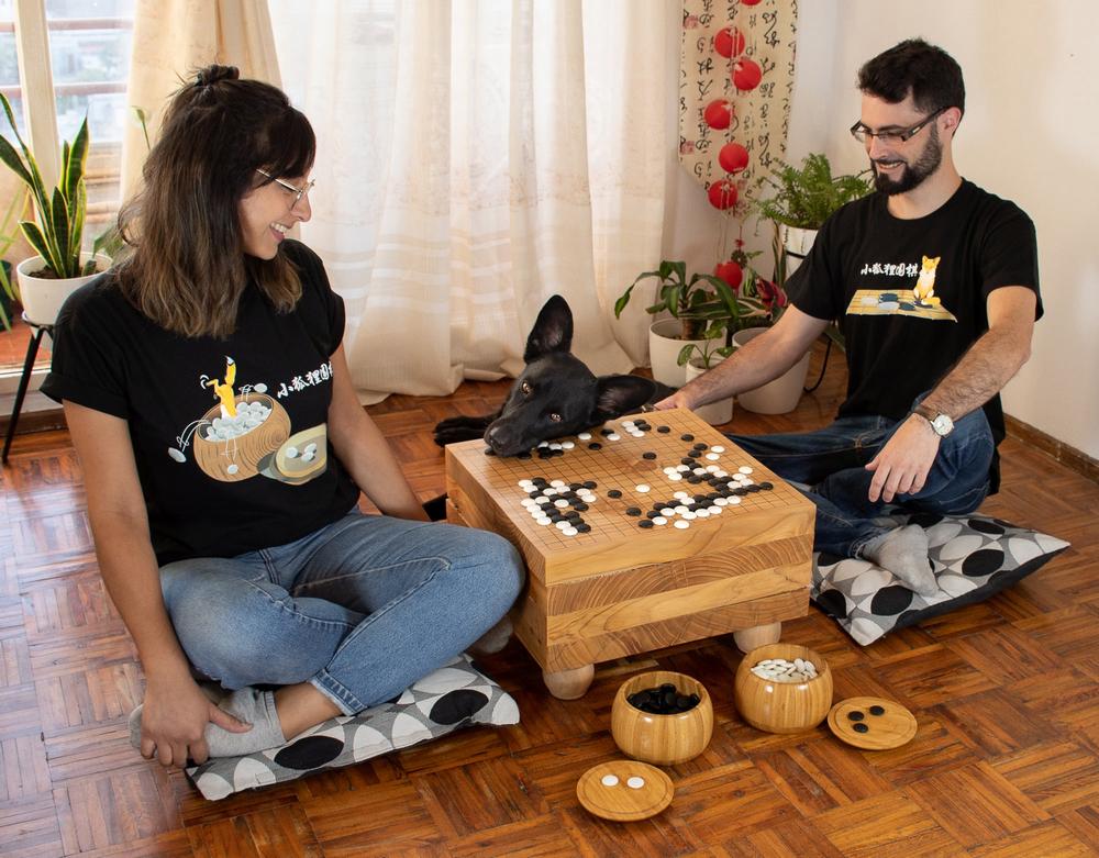 A couple and a dog make fun playing Go. The game of Go | Baduk | Weiqi.