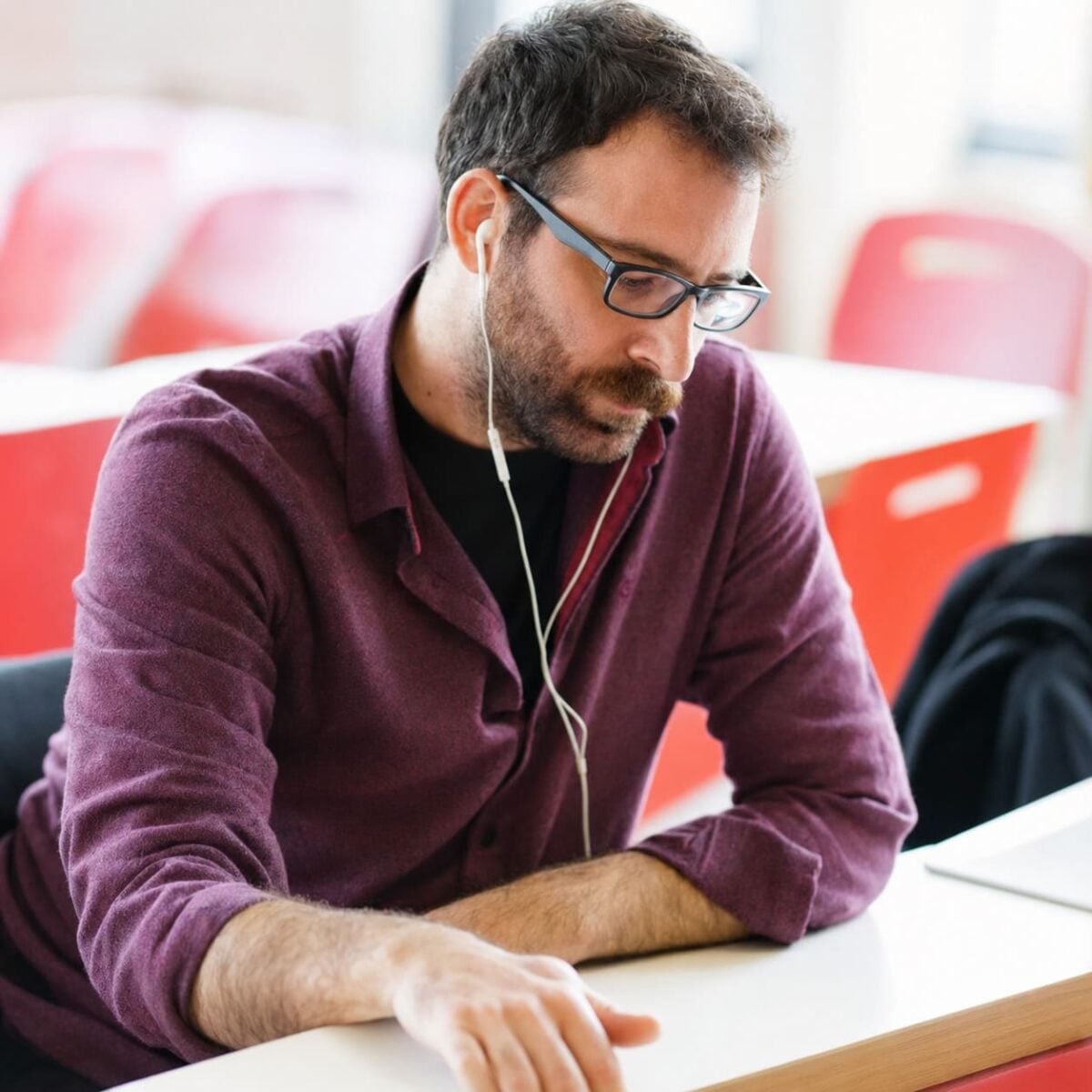 Ahmet Eren Kurter wearing glasses and earphones while concentrating at a table