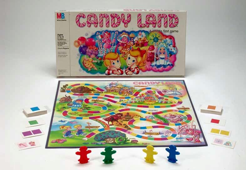 The classic Candy Land board game set up, with colorful paths and character pieces ready to play, and the game box featuring vibrant candy-themed illustrations in the background.