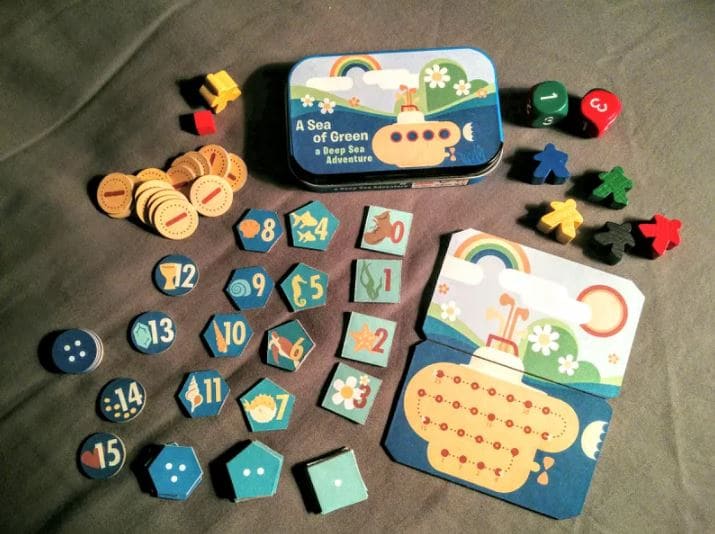 Components of the board game 'A Sea of Green: Deep Sea Adventure,' including tiles and tokens.