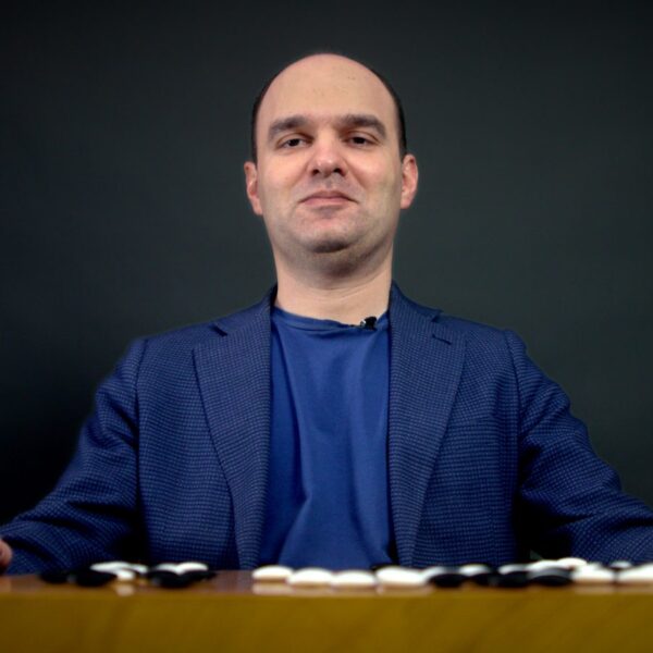 Alexander Dinerstein looking confidently from behind a Go board