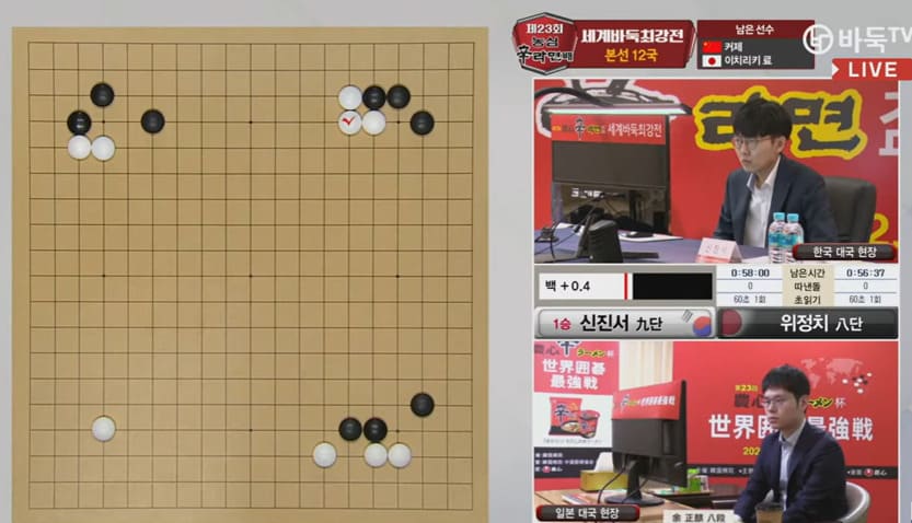 Go board with stones in the opening position beside a Korean live broadcast featuring a player at the table.