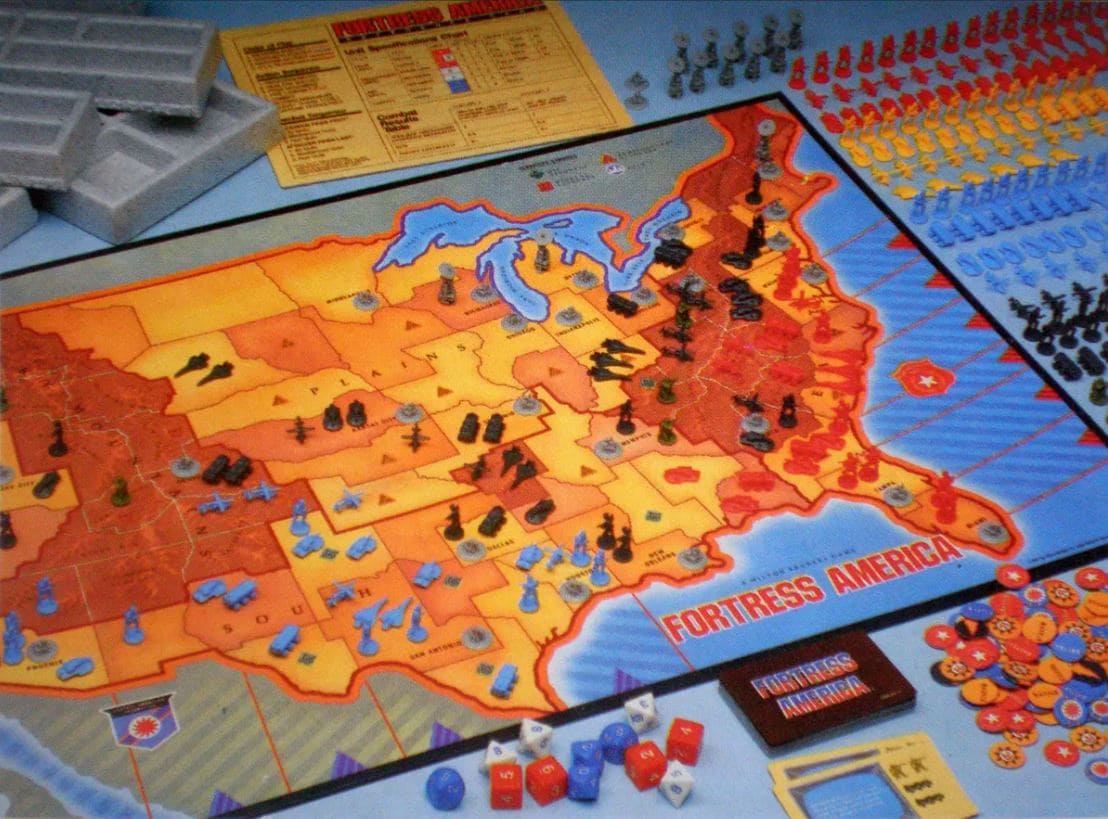 A close-up image of the "Fortress America" board game, depicting a map of the United States under attack by invading forces, with various game pieces and dice.