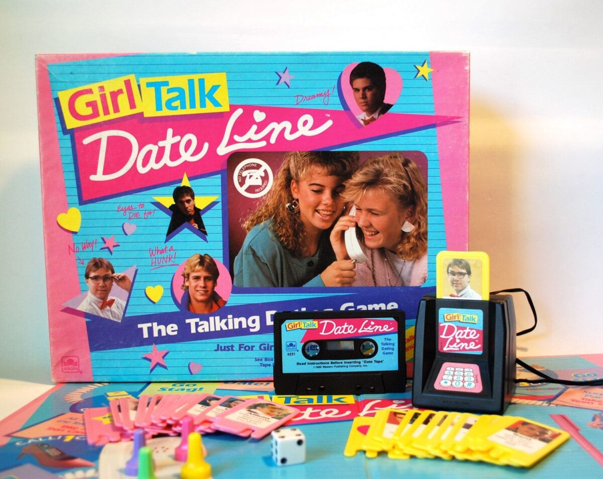 Girl Talk Date Line board game with a retro phone prop, player pieces, cards, and a colorful game box featuring 80s teen themes.