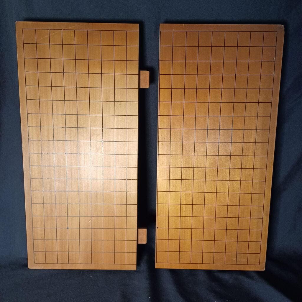 An old-fashioned two-piece folding Go board with visible hinge in the center