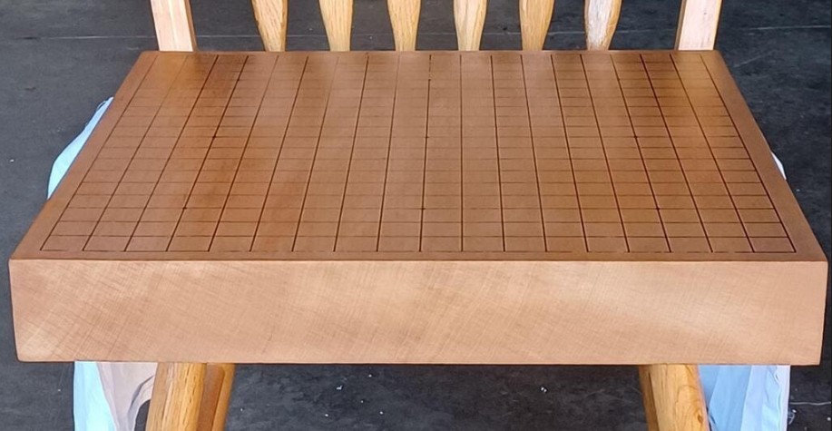 Light brown Agathis Go board placed on a wooden chair