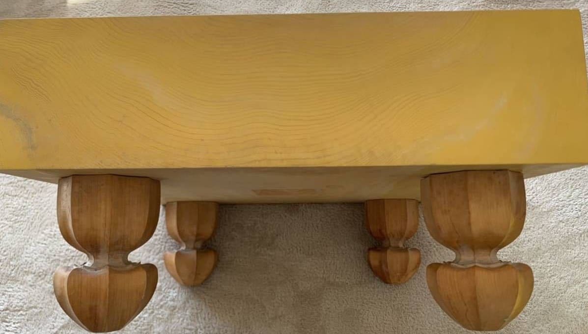Underside of a Go board showing natural wood grain and carved legs