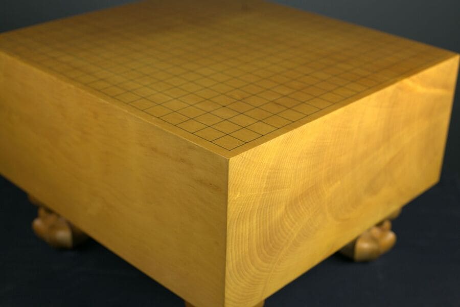 A traditional wooden goban with a smooth surface and fine grid lines, used for playing the game of Go.