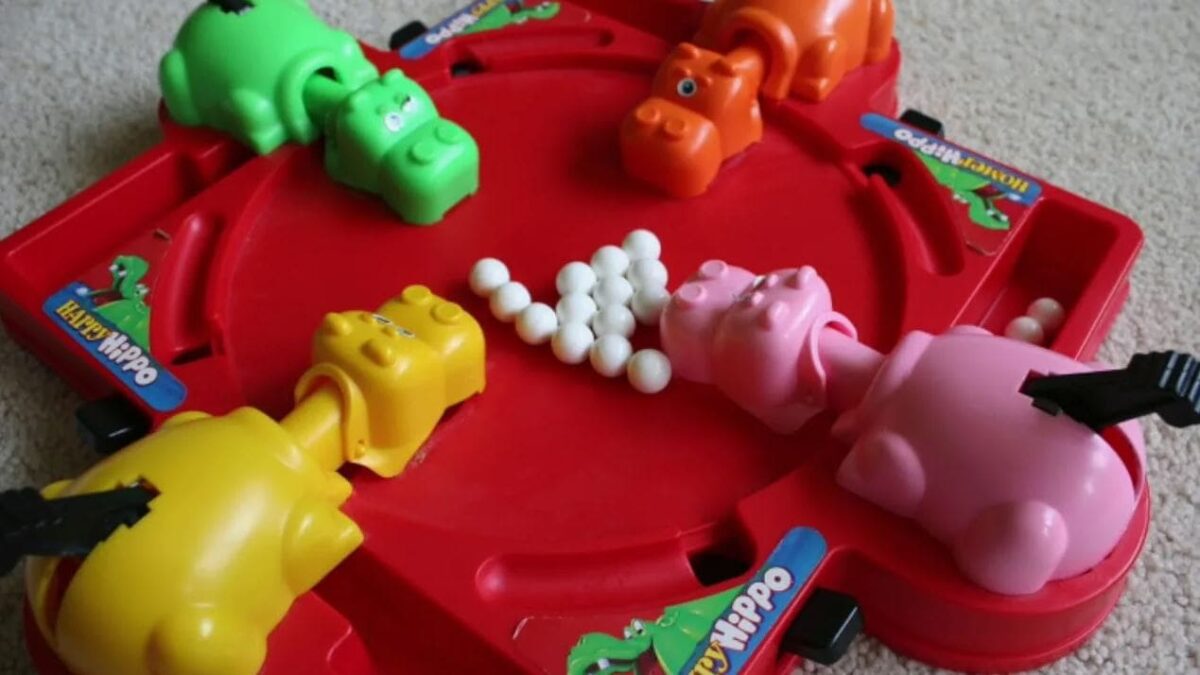 The Hungry Hungry Hippos game featuring colorful hippos eagerly snapping marbles on a bright red game base, representing fast-paced fun.