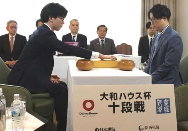 Iyama Yuta seated at the Go board during a Judan Cup match in a formal setting
