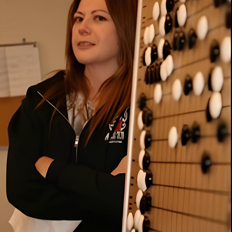 Janice Kim standing with folded arms beside a large Go board with stones