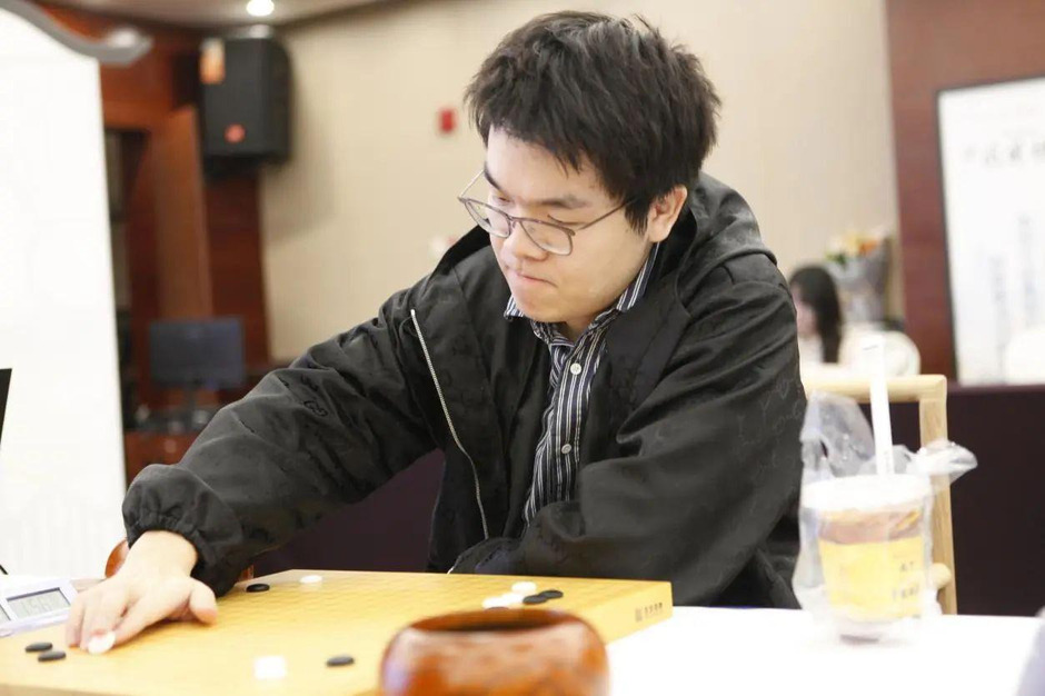 Ke Jie intensely focused on a Go board during a competitive tournament, demonstrating his exceptional skills.