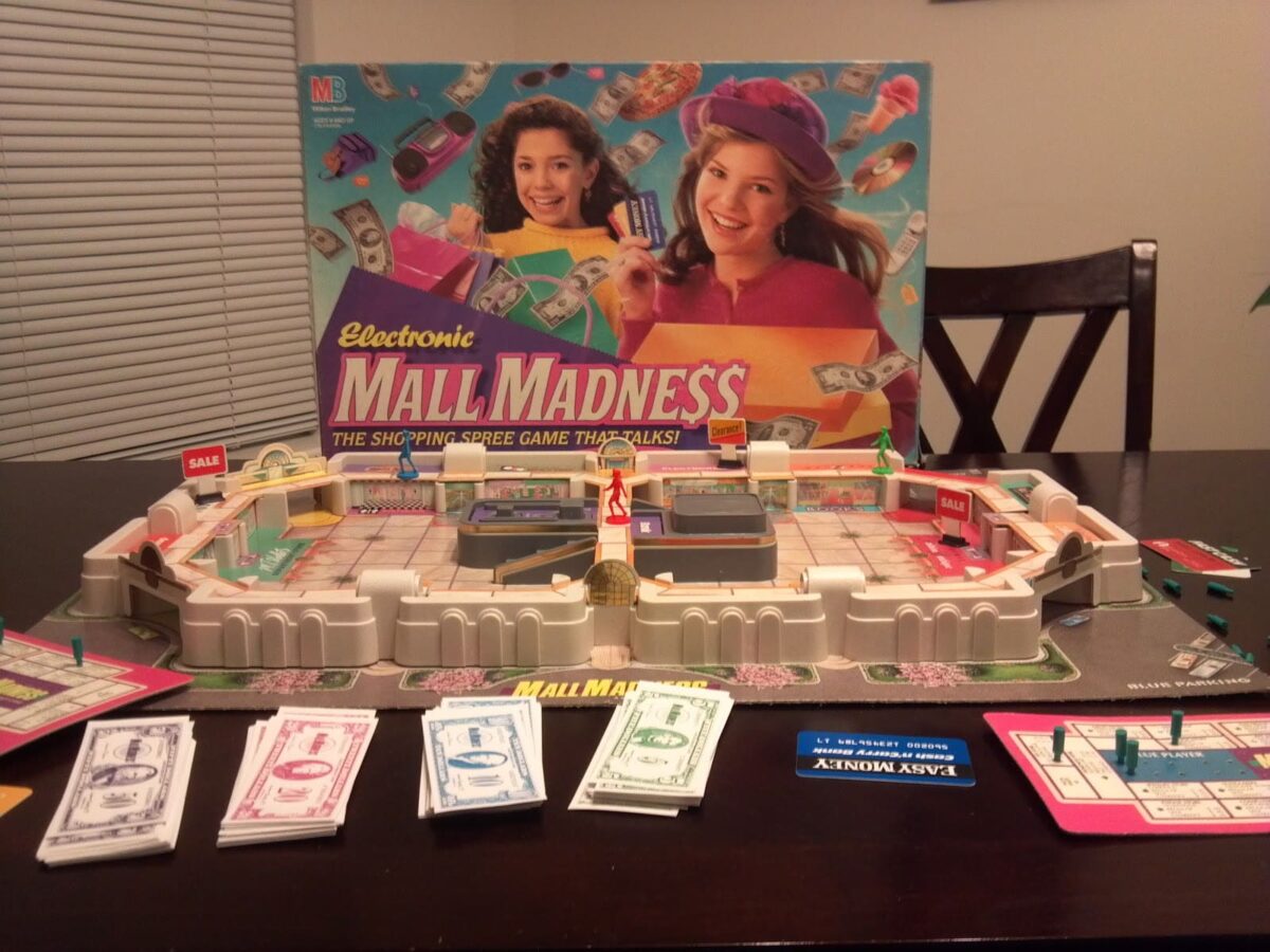 A classic 80s board game, Electronic Mall Madness, with a shopping mall setup and game money pieces.