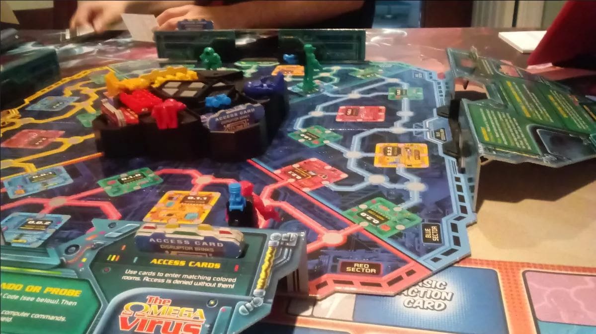 A colorful board setup of the 1990s Omega Virus board game, featuring robots and access cards on a futuristic circuit board layout.