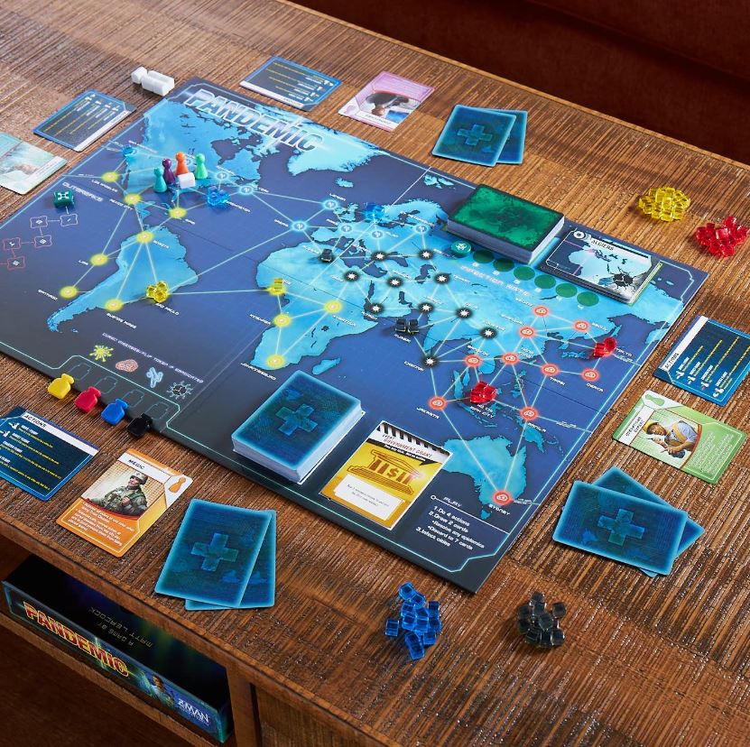 A detailed view of the Pandemic board game showing a map of the world with game pieces and cards spread out.