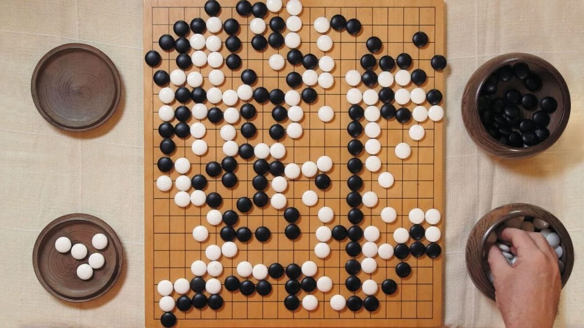 A top view of a Go board with black and white stones, symbolizing strategic thinking and adaptability in the game of Go.