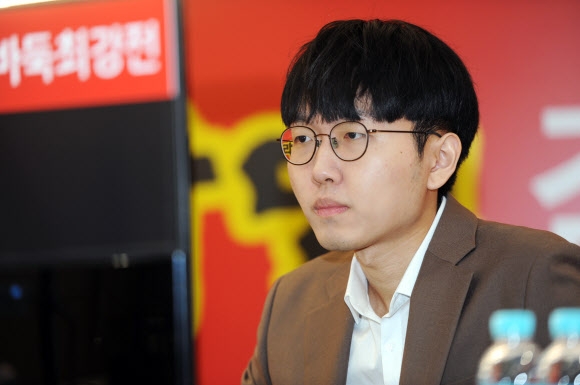 Shin Jinseo, professional Go player, concentrating during an important tournament, dressed in a suit with a serious expression.