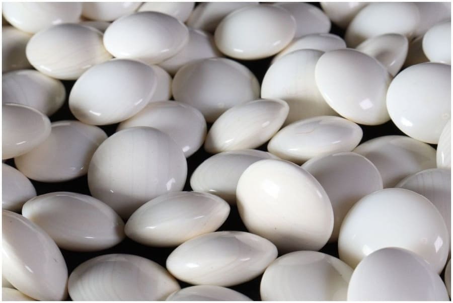 Close-up of glossy white Go stones, traditionally known as "shiro", used in professional and amateur Go games.