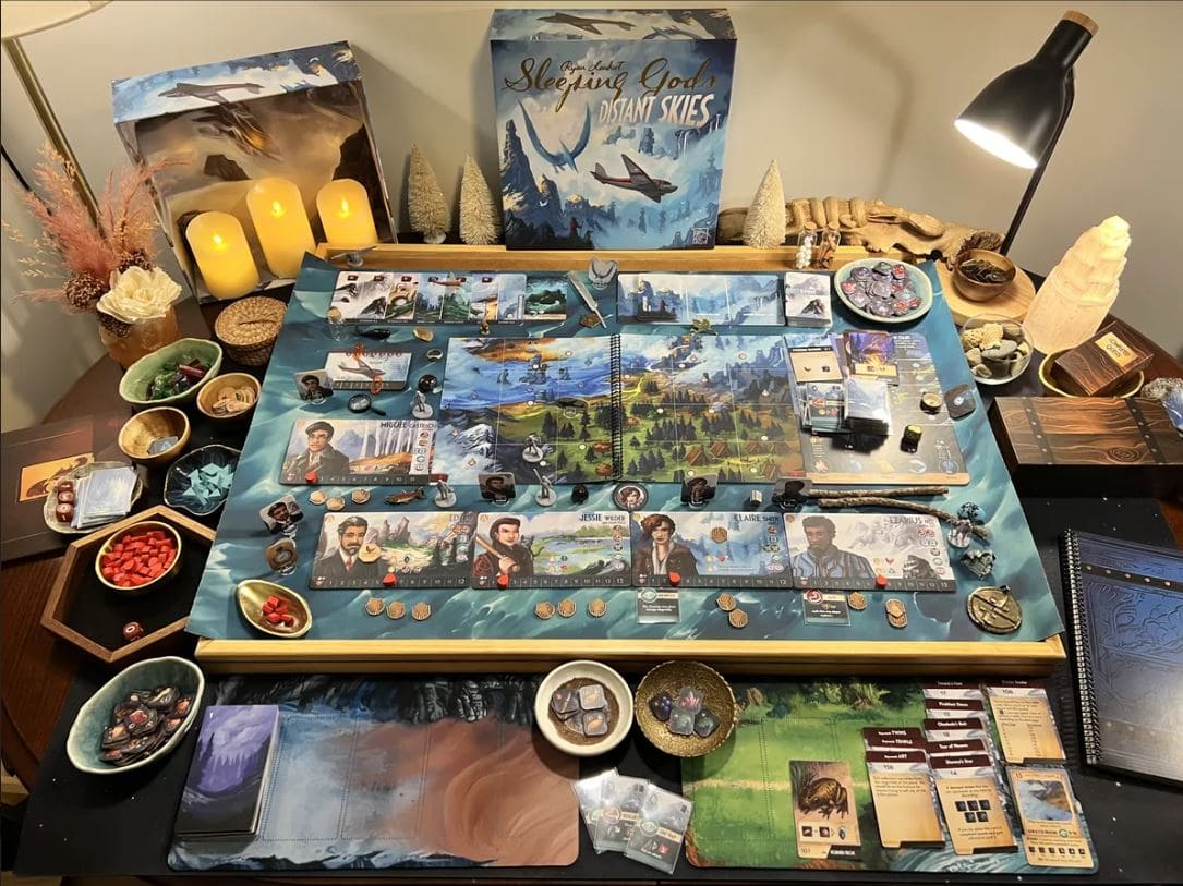 Complete board setup of Sleeping Gods: Distant Skies, showing detailed cards, tokens, and scenic artwork surrounding a deep narrative-driven adventure.